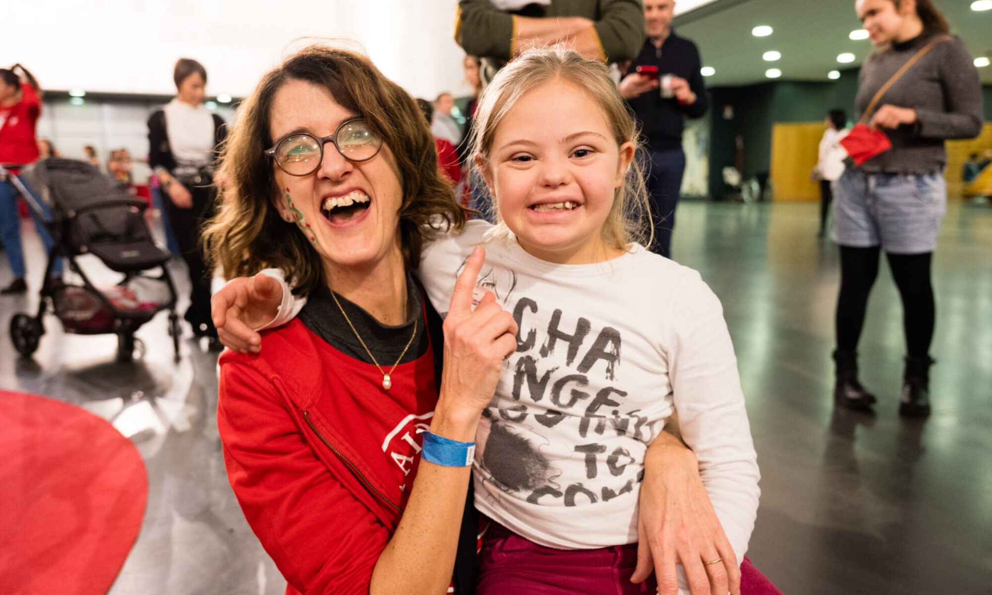 Un'operatrice di Paideia e una bambina che sorridono verso l'obiettivo.